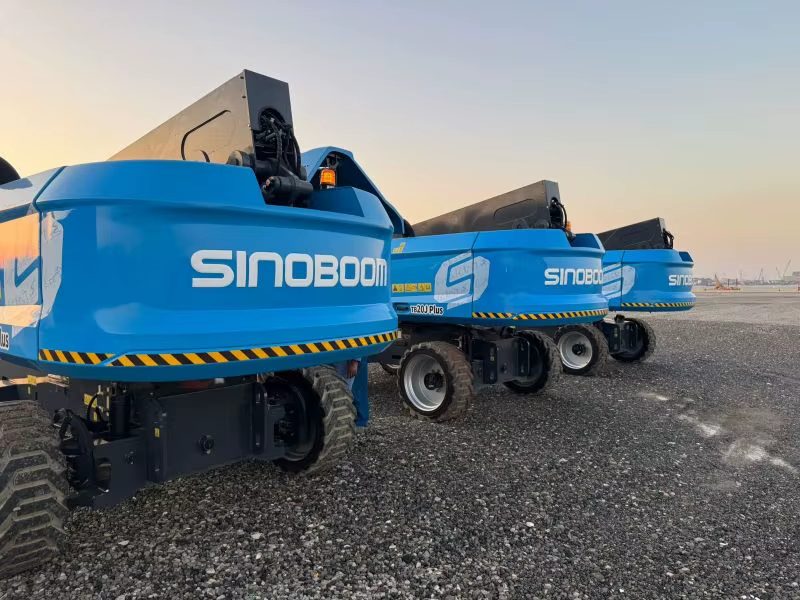 Sinoboom boom lifts lined up at dusk ready for delivery